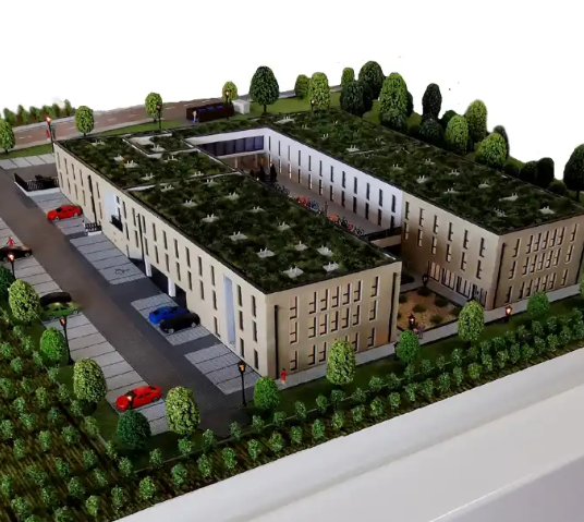 Eine kuratierte Messeszene für die Vienna Design Week mit einer maßgeschneiderten, beleuchteten und animierten Architekturmaquette von ARI Modellbau: ein innovationsgetriebenes Mixed-Use-Quartier mit EV-Ladeplätzen, autonomen Shuttle-Routen, material